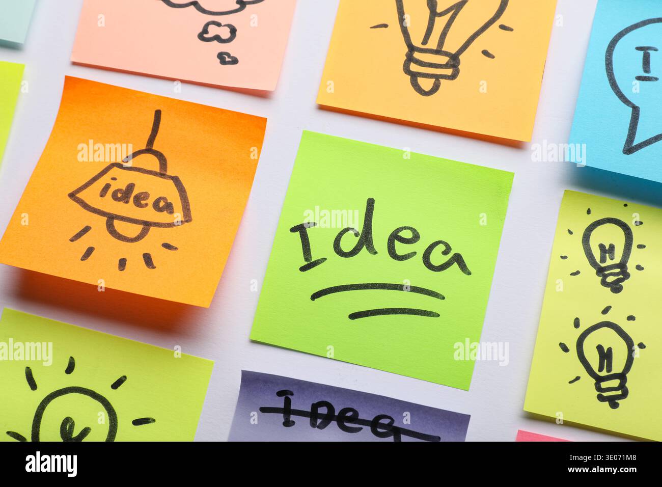 Sticky notes with drawn light bulbs and words IDEA on grey background. Business idea concept Stock Photo