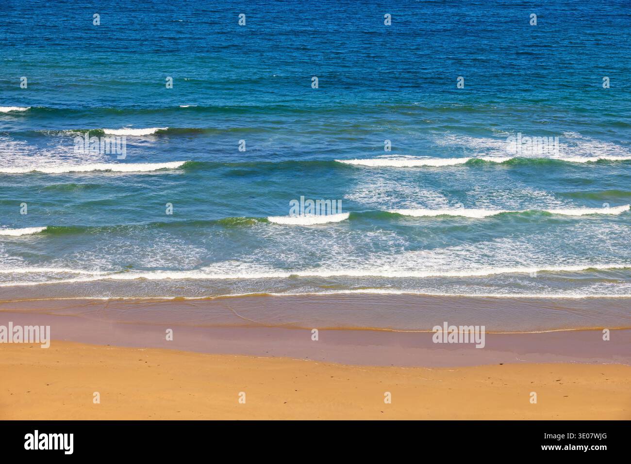 Breaking sea waves at a sand beach Stock Photo