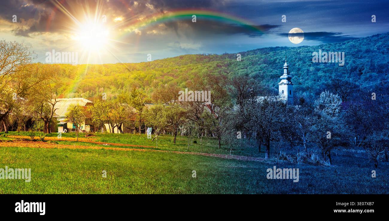mountainous countryside landscape in spring. day meet night. sun and moon over wonderful weather with cloudy sky. rural orchard in the outskirts of th Stock Photo
