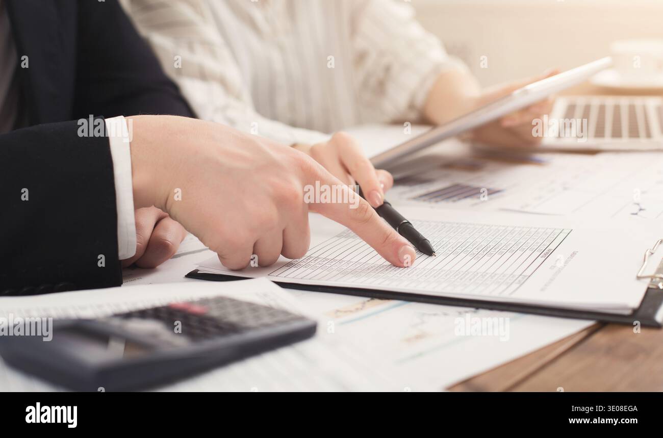 Business colleagues checking documents and using calculator Stock Photo