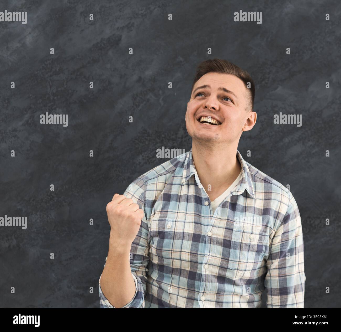 Satisfied young man celebrating success Stock Photo
