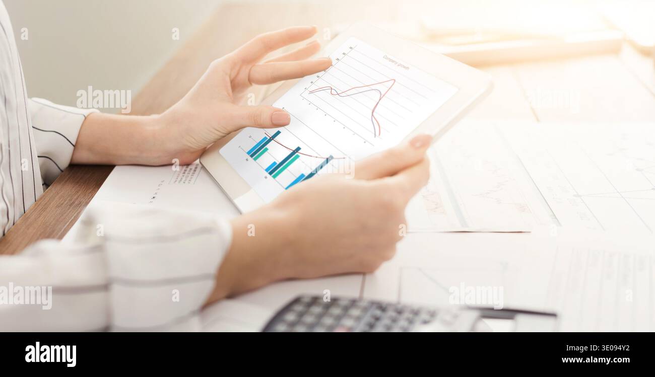 Woman looking at graph on digital tablet Stock Photo