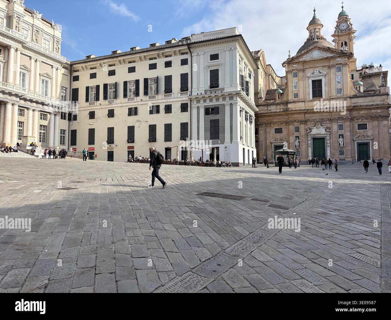 Palazzo Ducale, Piazza de Ferrari, Genoa, Italy. Historic Baroque architecture framing a large stone-paved piazza with tourists and pedestrians. Stock Photo