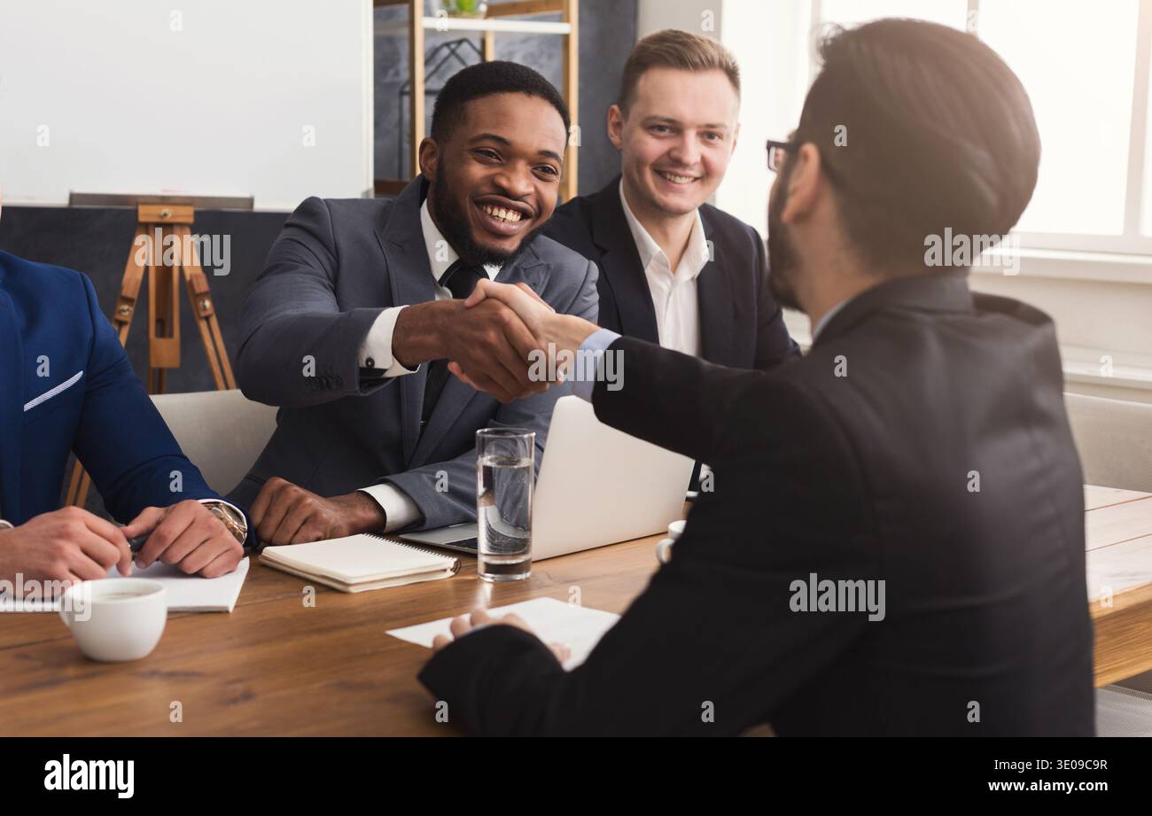 Business handshake at multiethnic office meeting Stock Photo