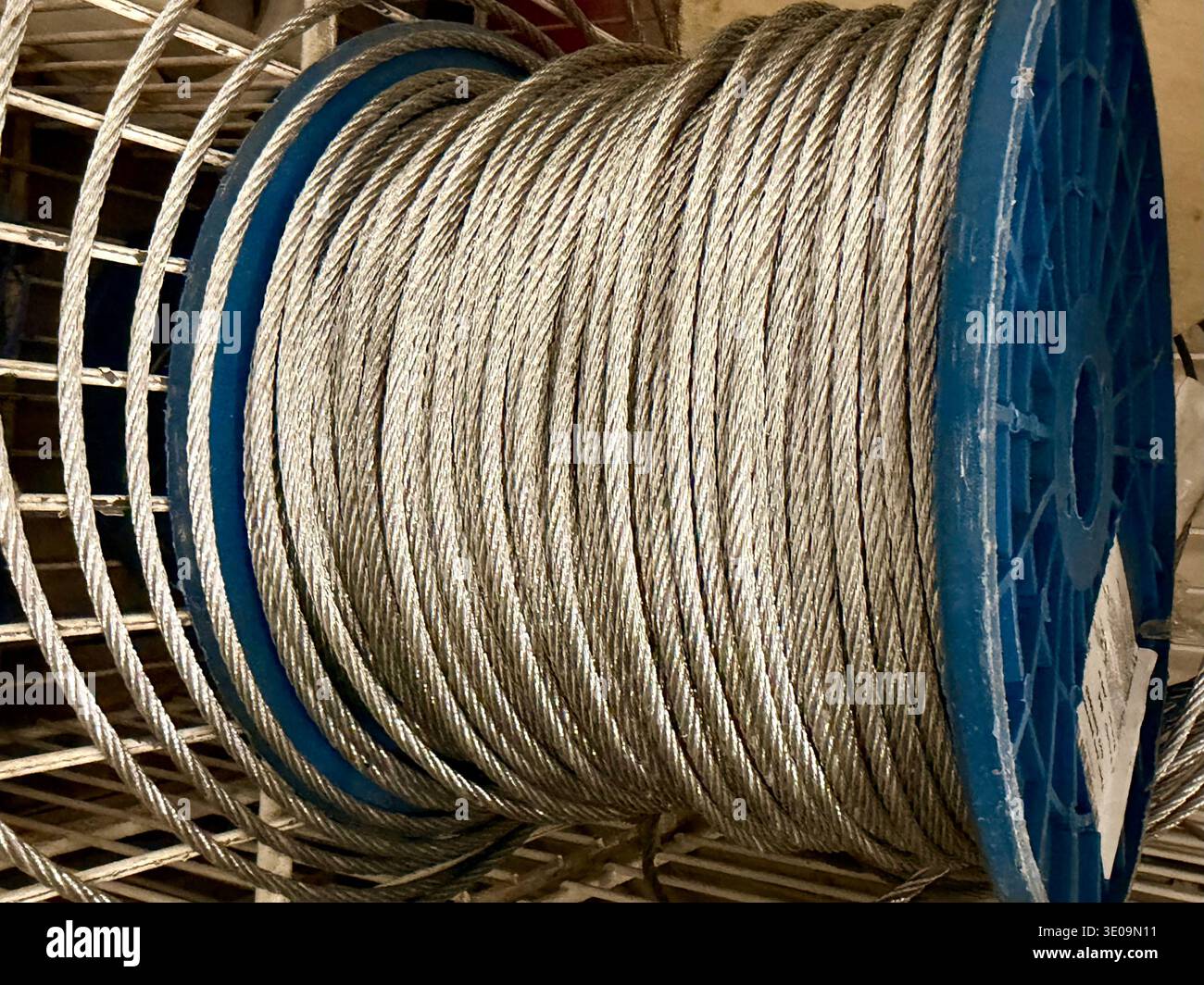 Steel wire rope wound on blue spool in hardware store or industrial ...