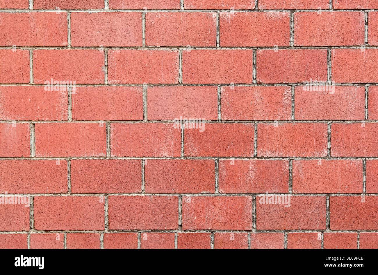 Modern red brick wall background with cracks in concrete Stock Photo