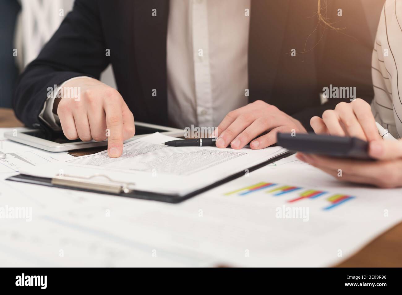Business colleagues checking documents and using calculator Stock Photo