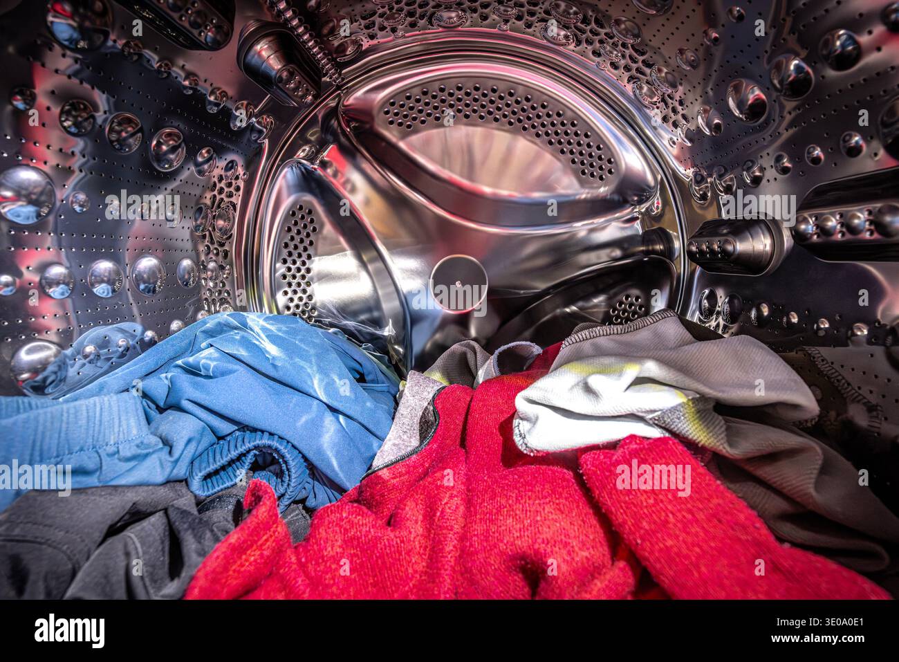 Colorful clothes inside a stainless steel washing machine drum Stock Photo