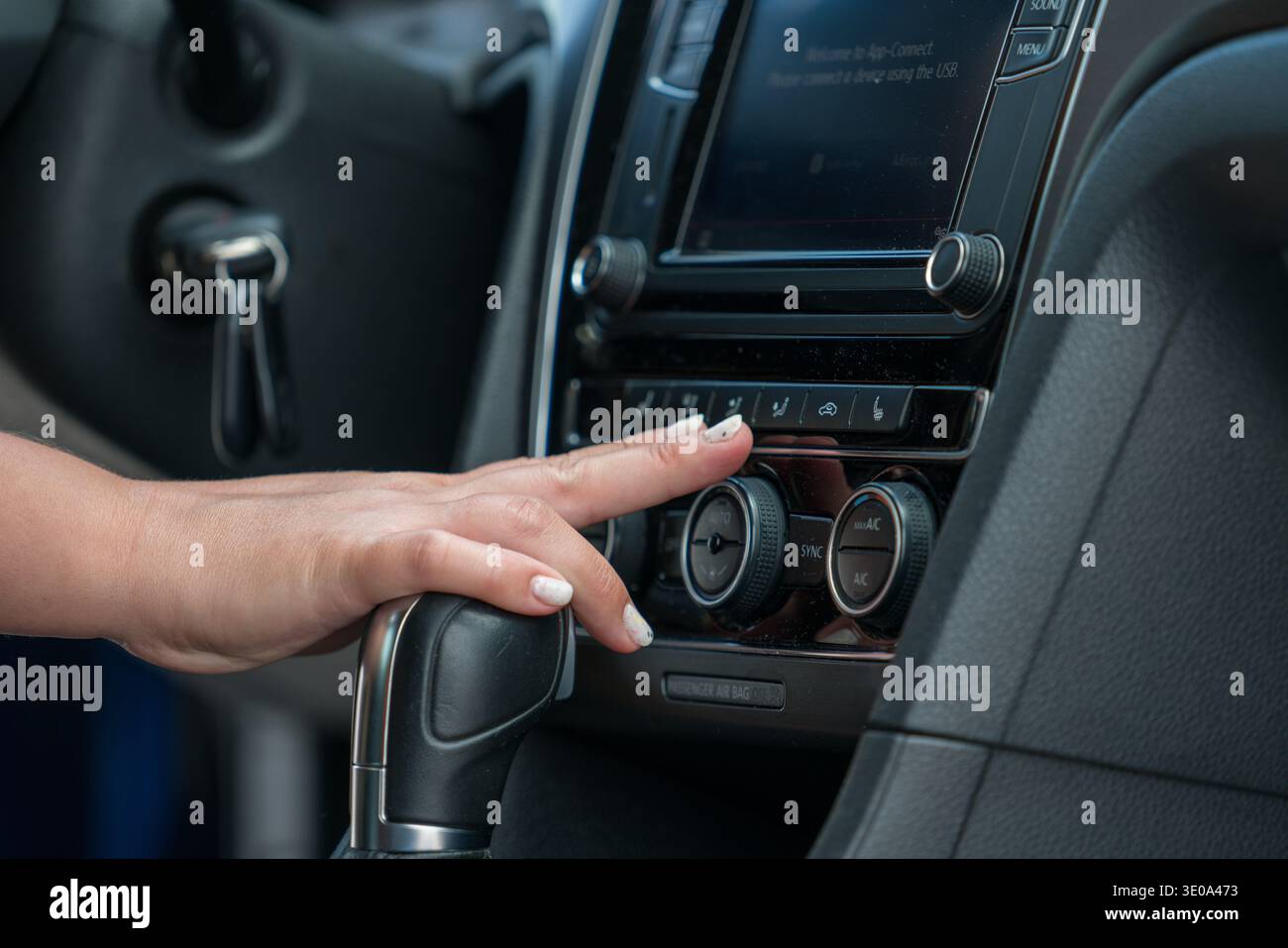 Hand adjusting car climate control air conditioning panel Stock Photo