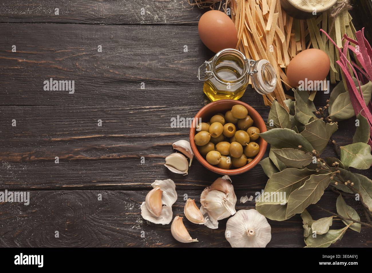 Collage of Cooking Ingredients With Olives, Garlic, Pasta, and Eggs on Rustic Wooden Table Stock Photo