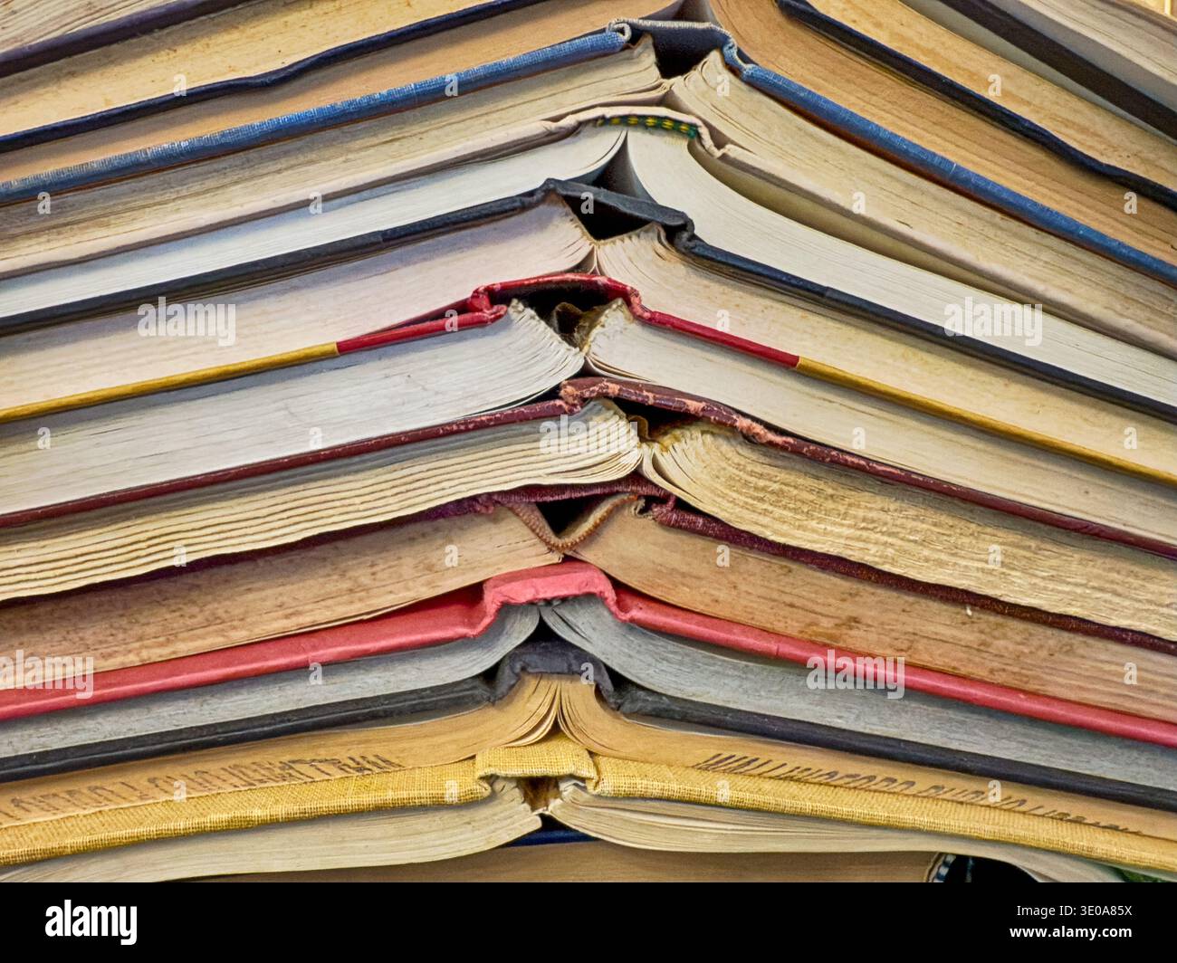A stack of books are opened but layered at the spines in a heap Stock ...