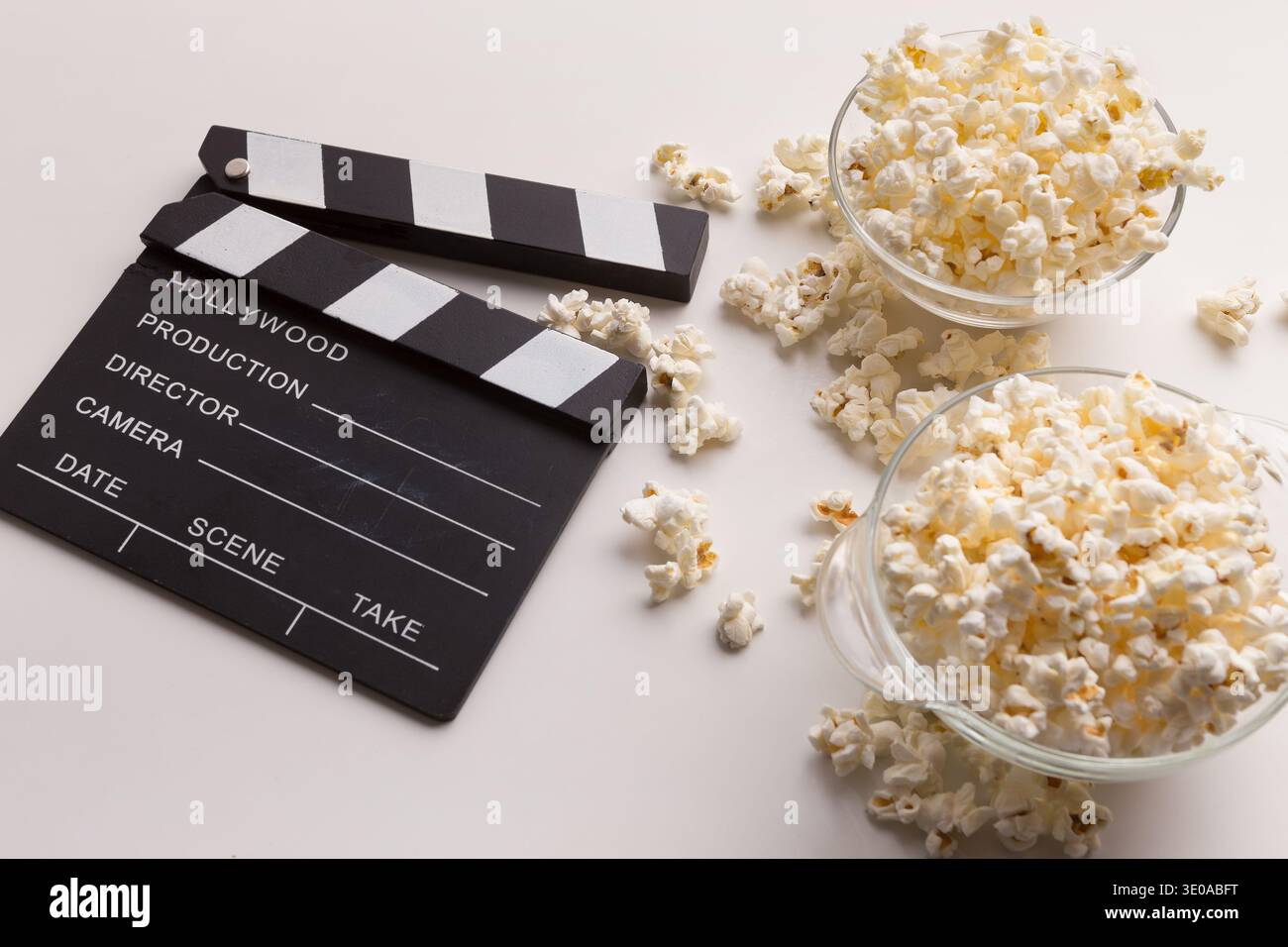 Clapperboard and popcorn on white background Stock Photo