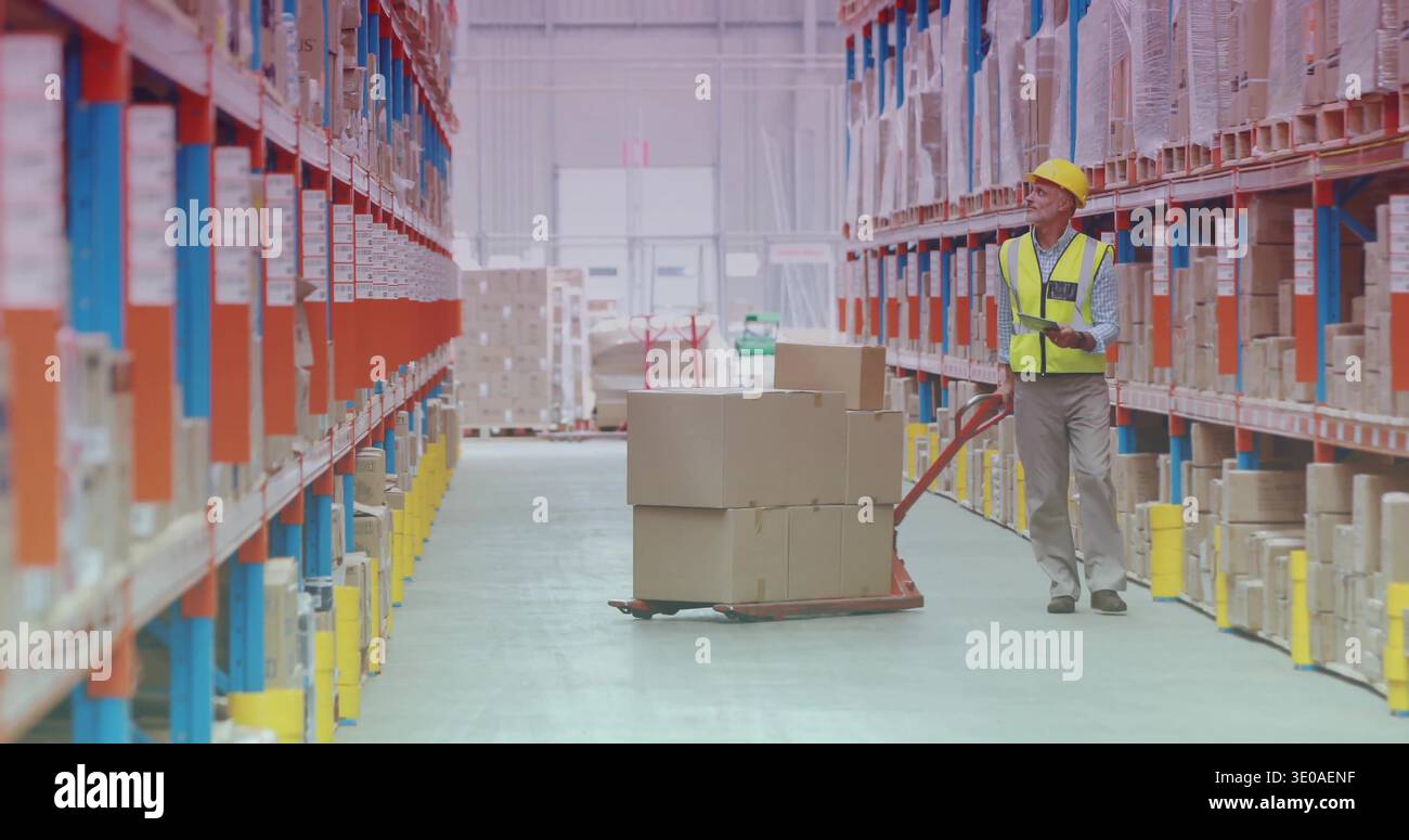 Scanning worker wearing yellow hard hat hi-vis vest with scanner by pallet jack, copy space Stock Photo