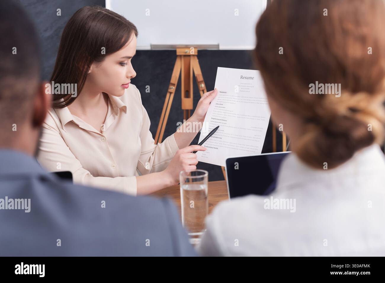 Young woman holding her resume during interview Stock Photo