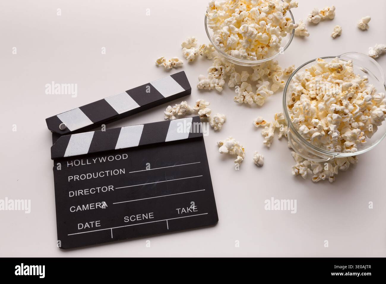 Clapperboard and popcorn on white background Stock Photo