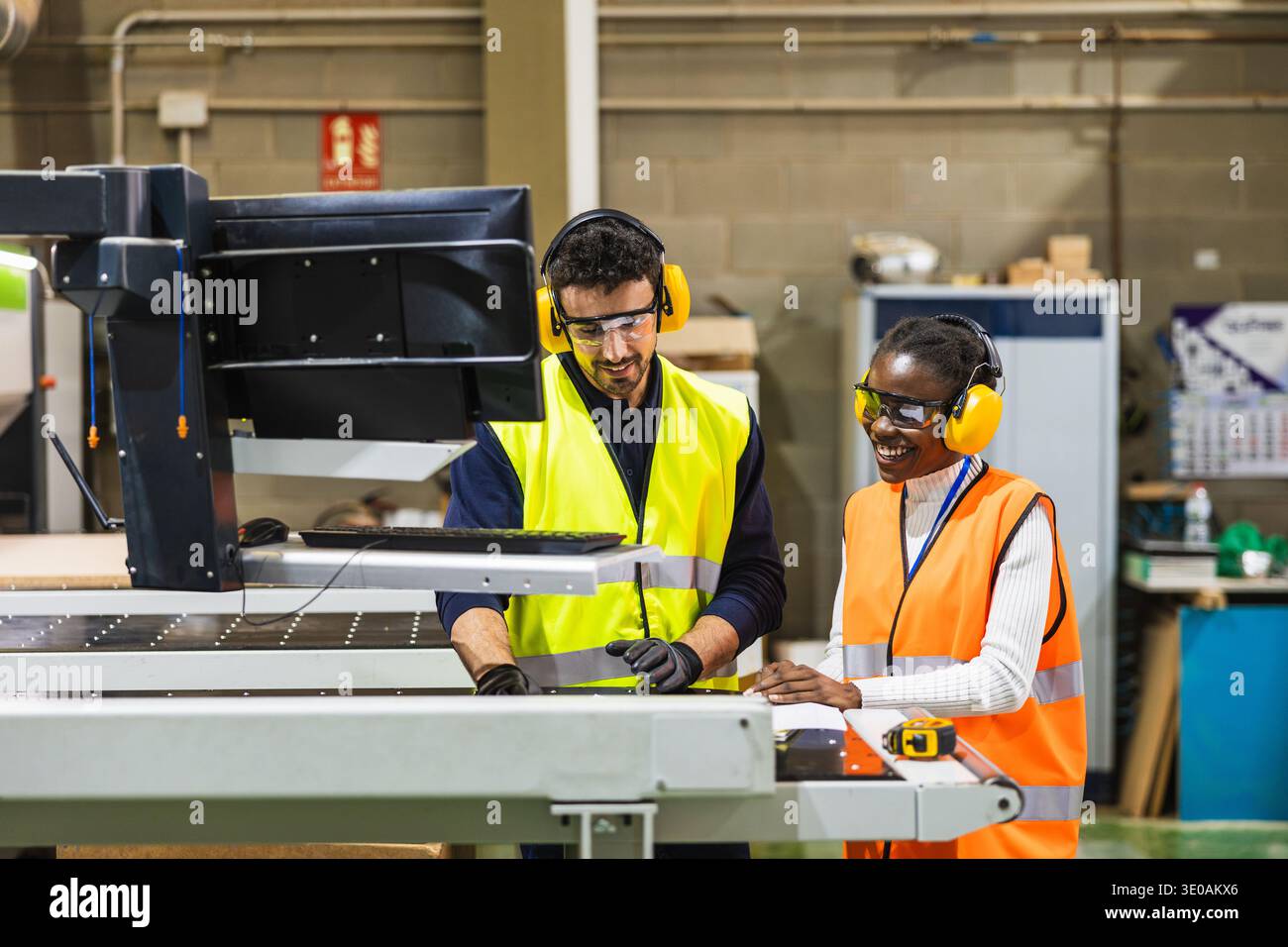 Diverse industrial workers collaborating on cnc machine control Stock Photo