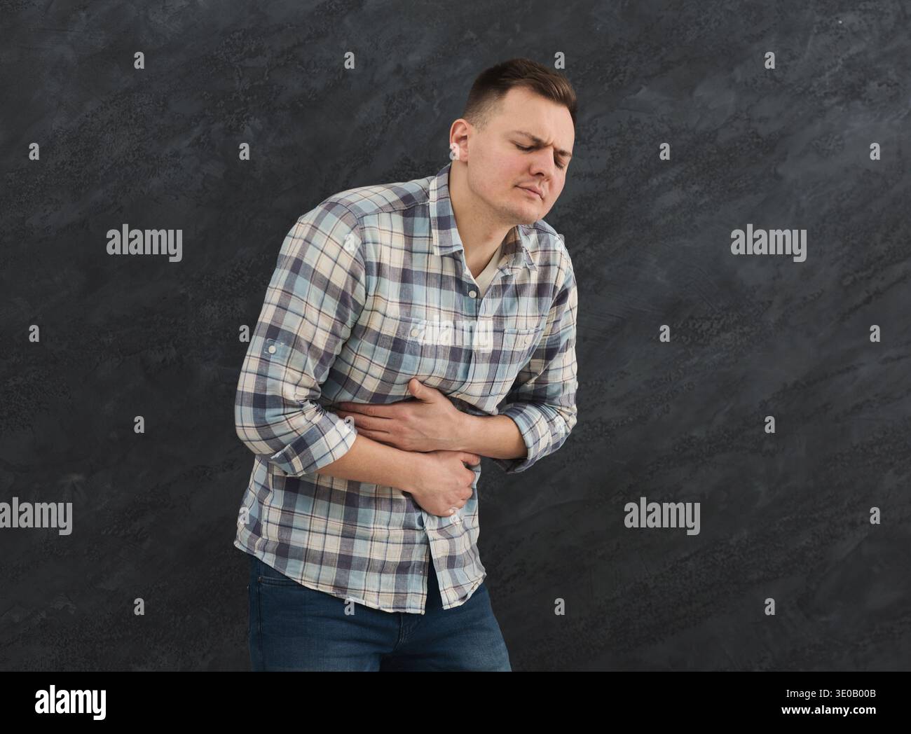 Frustrated handsome young man with stomachache Stock Photo