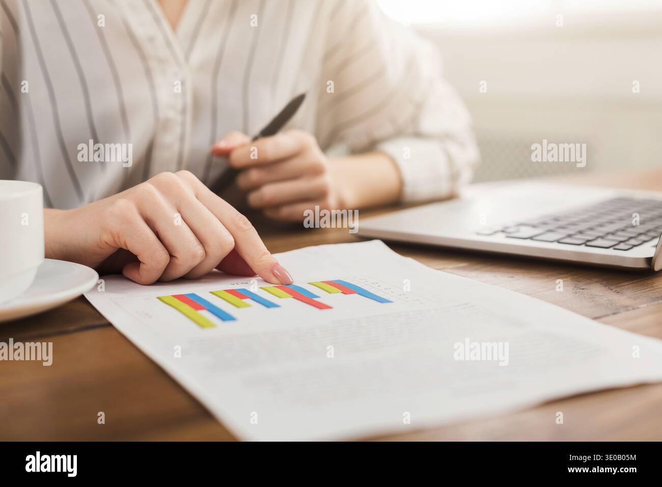 Woman analyzing business statistics holding diagrams Stock Photo