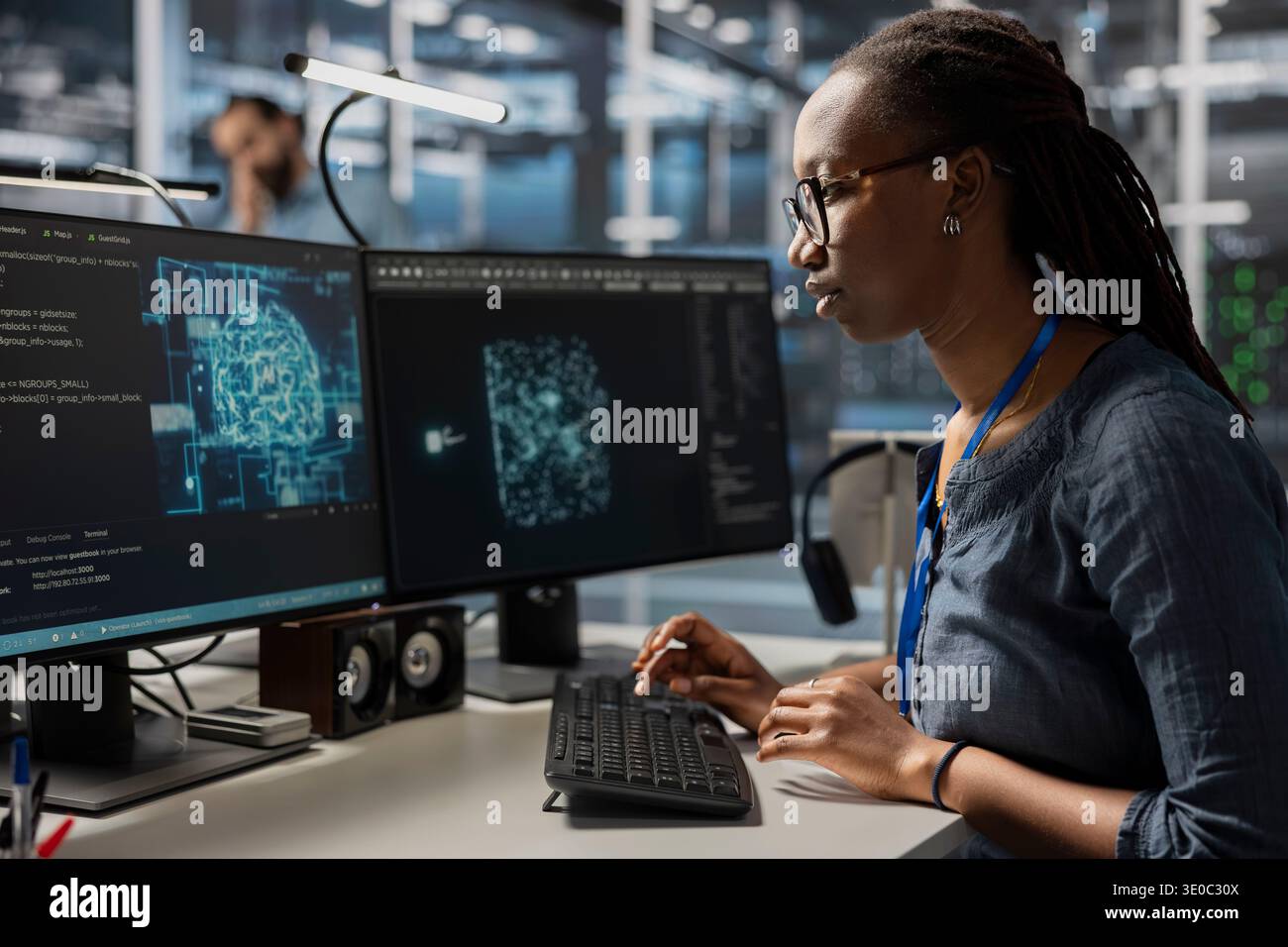 Data center developer using artificial intelligence machine learning tech. African american woman in server farm using AI programming language on computer to update equipment Stock Photo