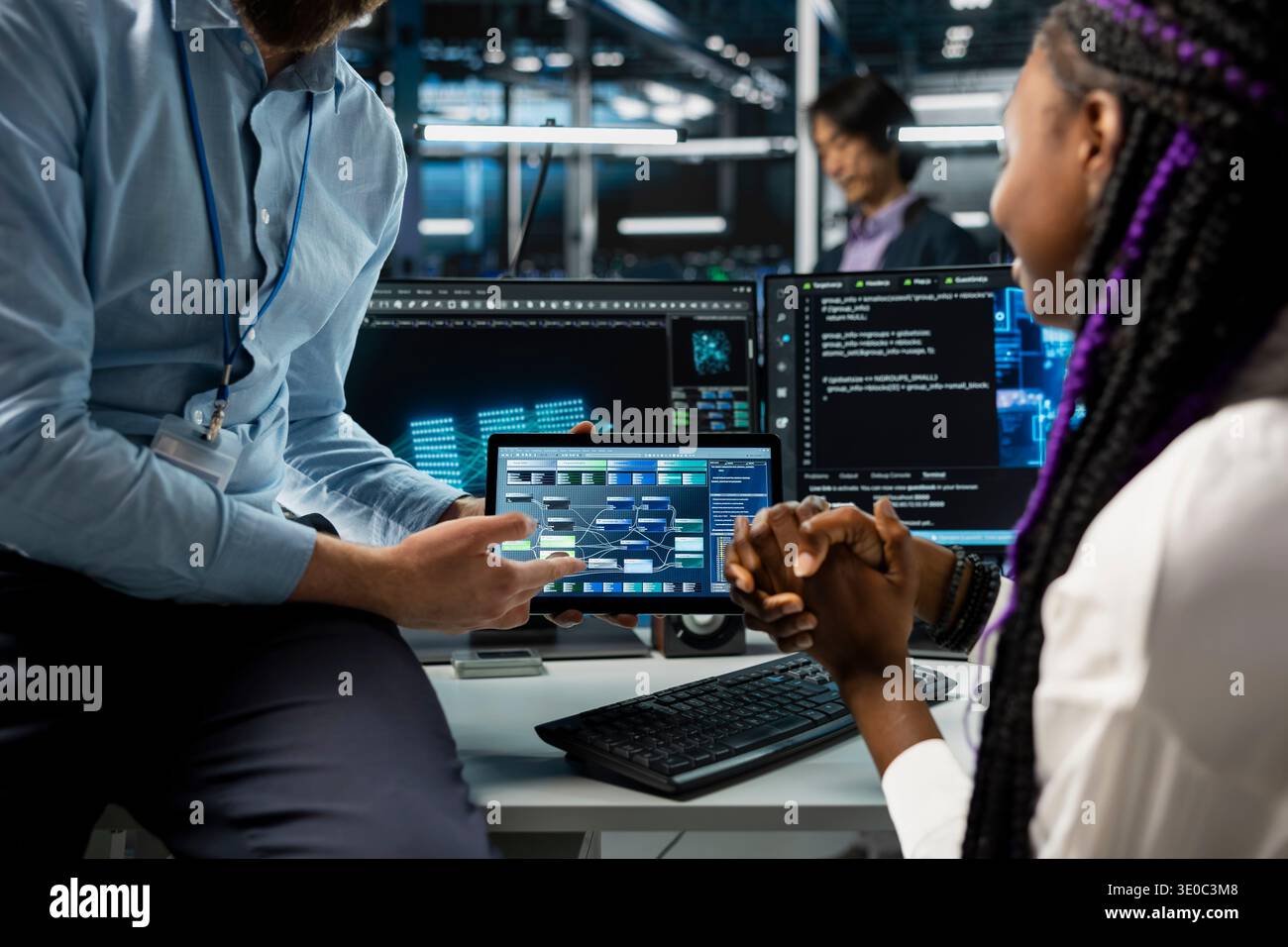 Close up of programmers coding on tablet in data center, using machine learning tech. IT professionals using device in server room, managing automation scripts for optimized operations Stock Photo