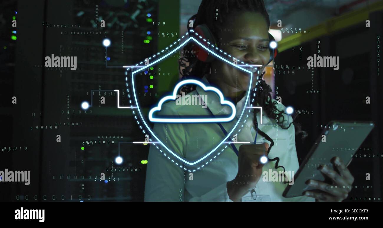 Standing tech wearing white shirt, badge and headset, using tablet, checking LEDs with cloud shield Stock Photo