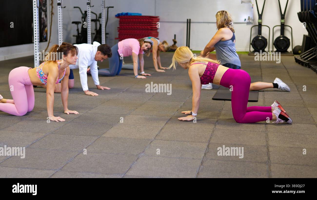 Fitness group training in gym performing cat cow exercise Stock Photo