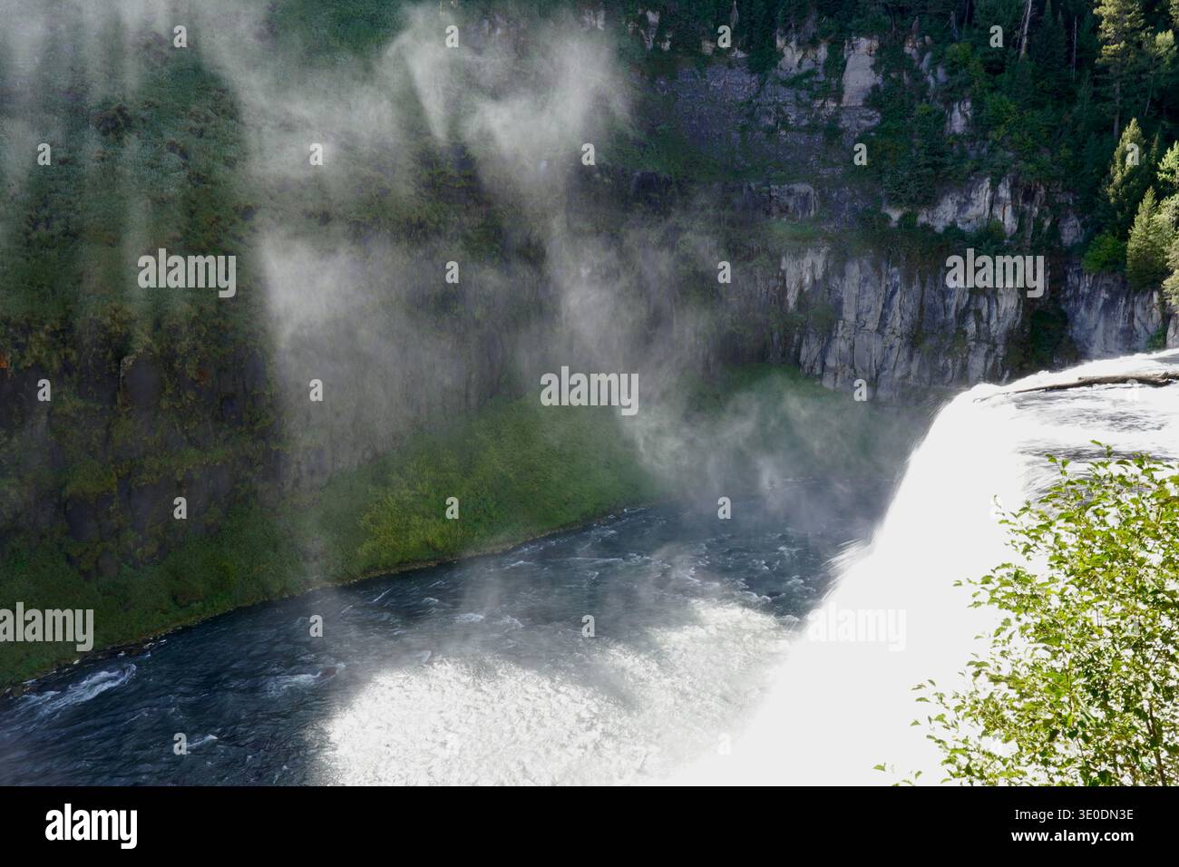 Light refractions shining through mist from waterfall at Mesa Falls Idaho Stock Photo