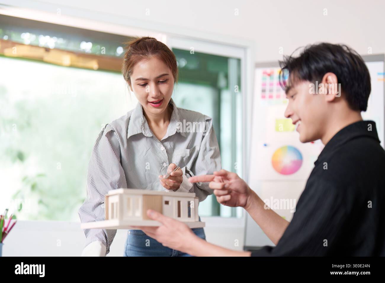 Architects Collaborating on Building Model and Design Plans Stock Photo