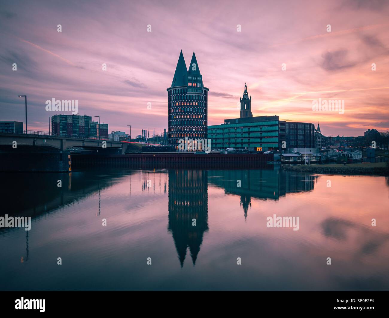Aerial view of the Munster Tower rises majestically, its reflection shimmering in the tranquil water under the pastel sky, Roermond, Limburg, Netherla Stock Photo