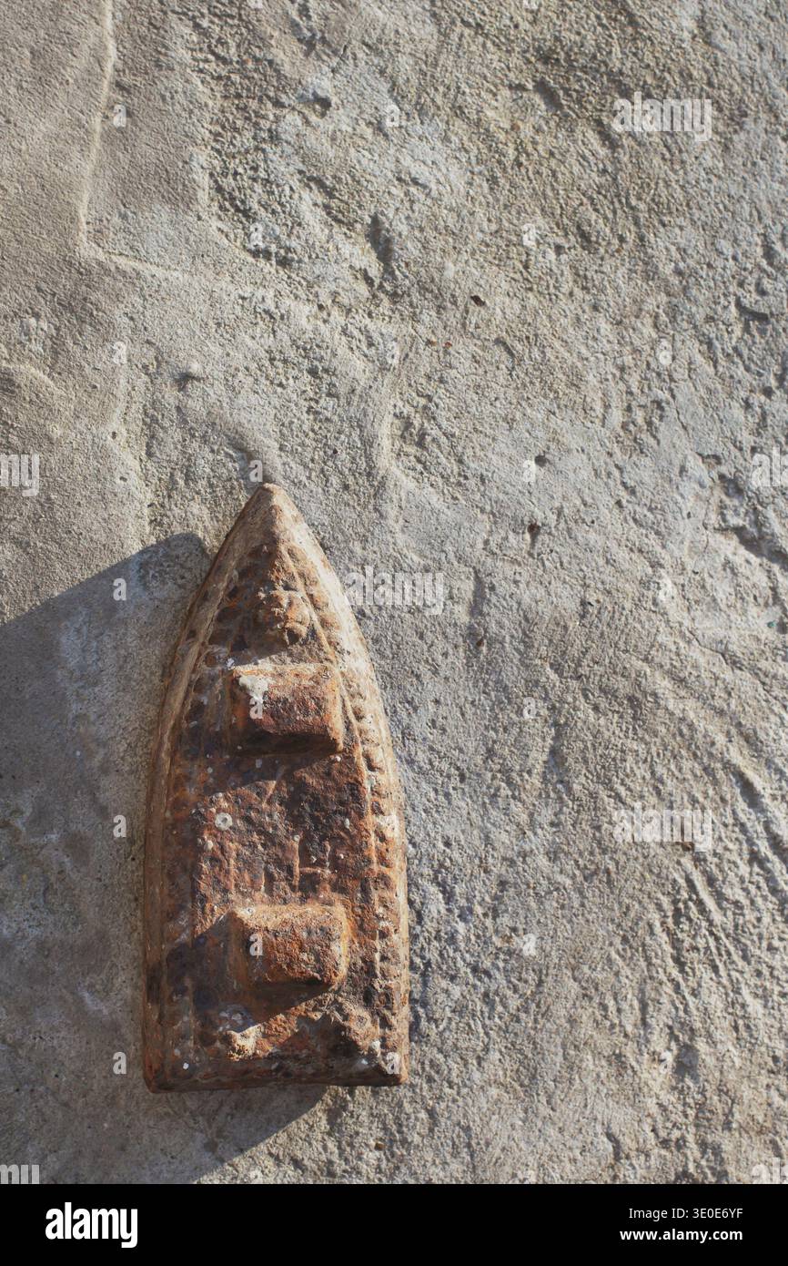 Vertical shot of an old cast-iron flatiron, vintage smoothing tool on concrete. Stock Photo