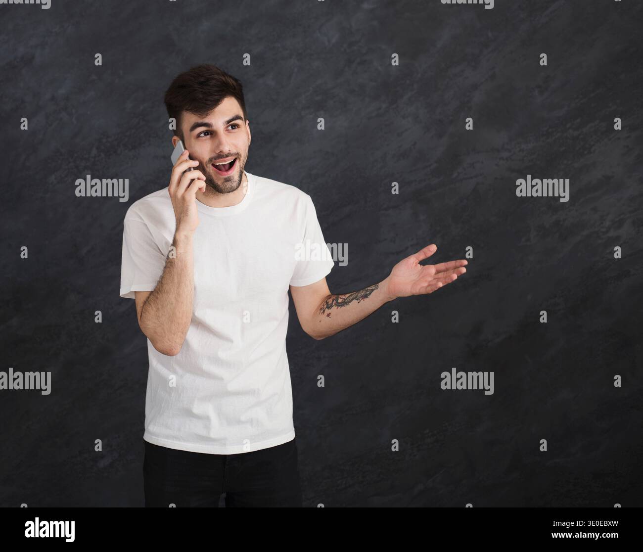 Excited man having pleasant conversation on smartphone Stock Photo