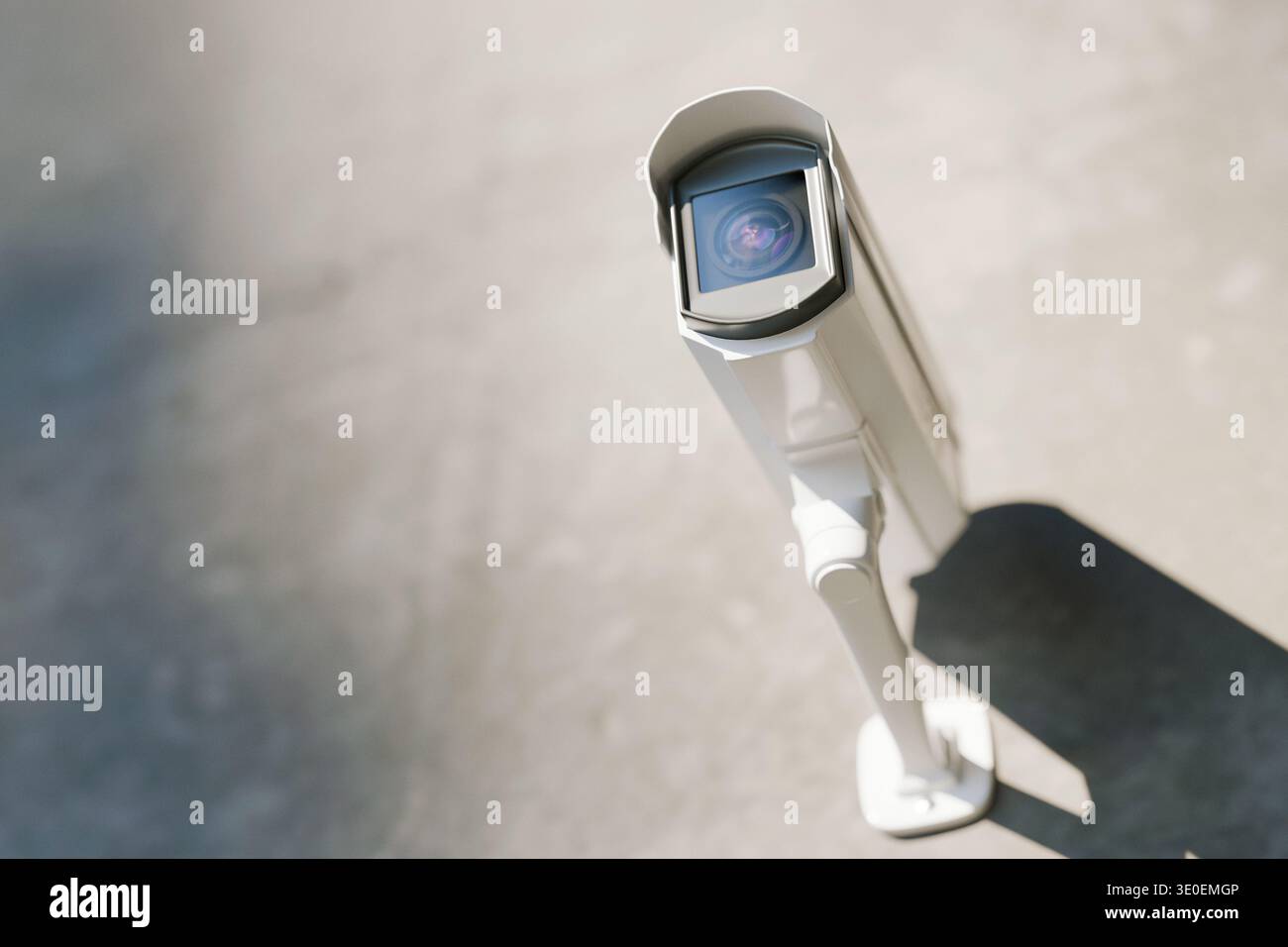 Modern outdoor white security camera mounted on a wall, providing surveillance and protection. High-tech CCTV system for safety, monitoring, and crime Stock Photo