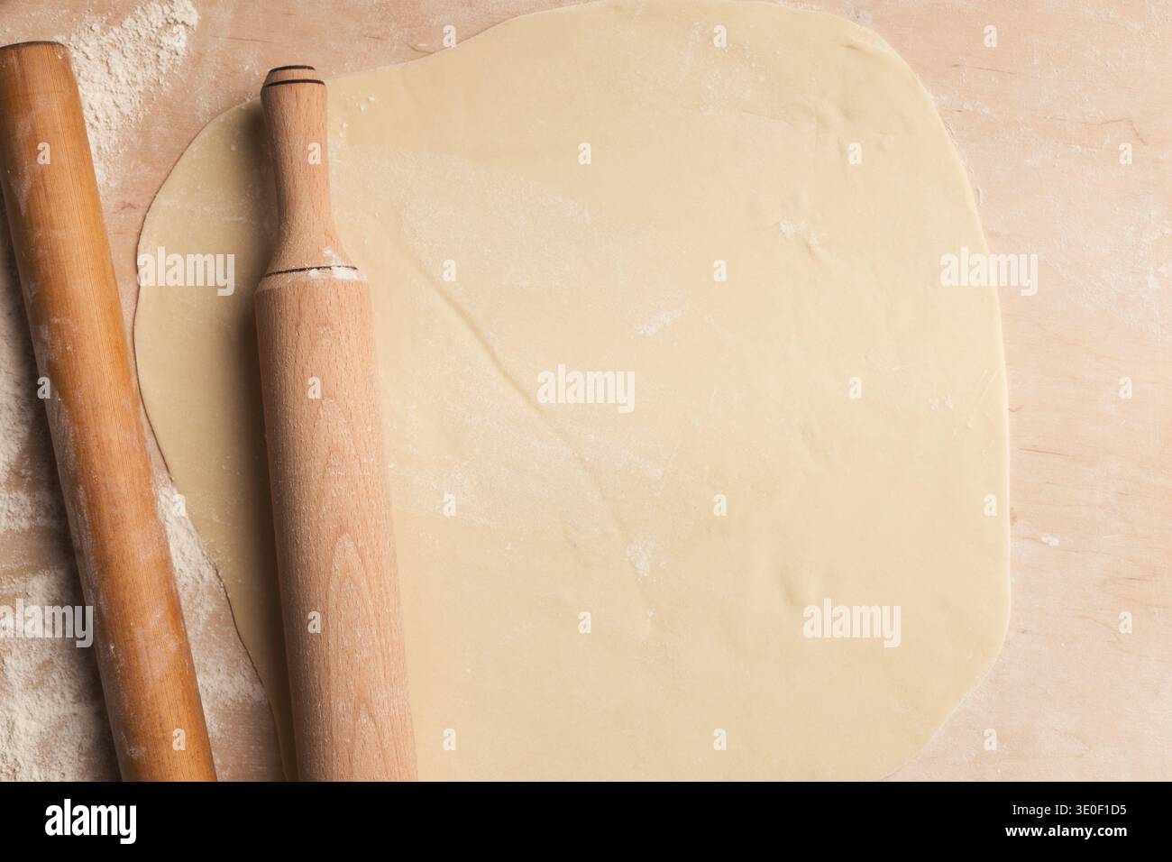 Rolled out dough on table with rolling pins Stock Photo