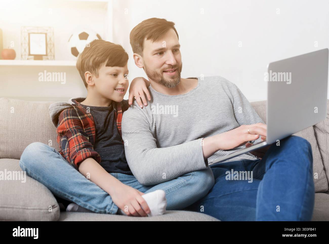 Father and son using laptop at home Stock Photo