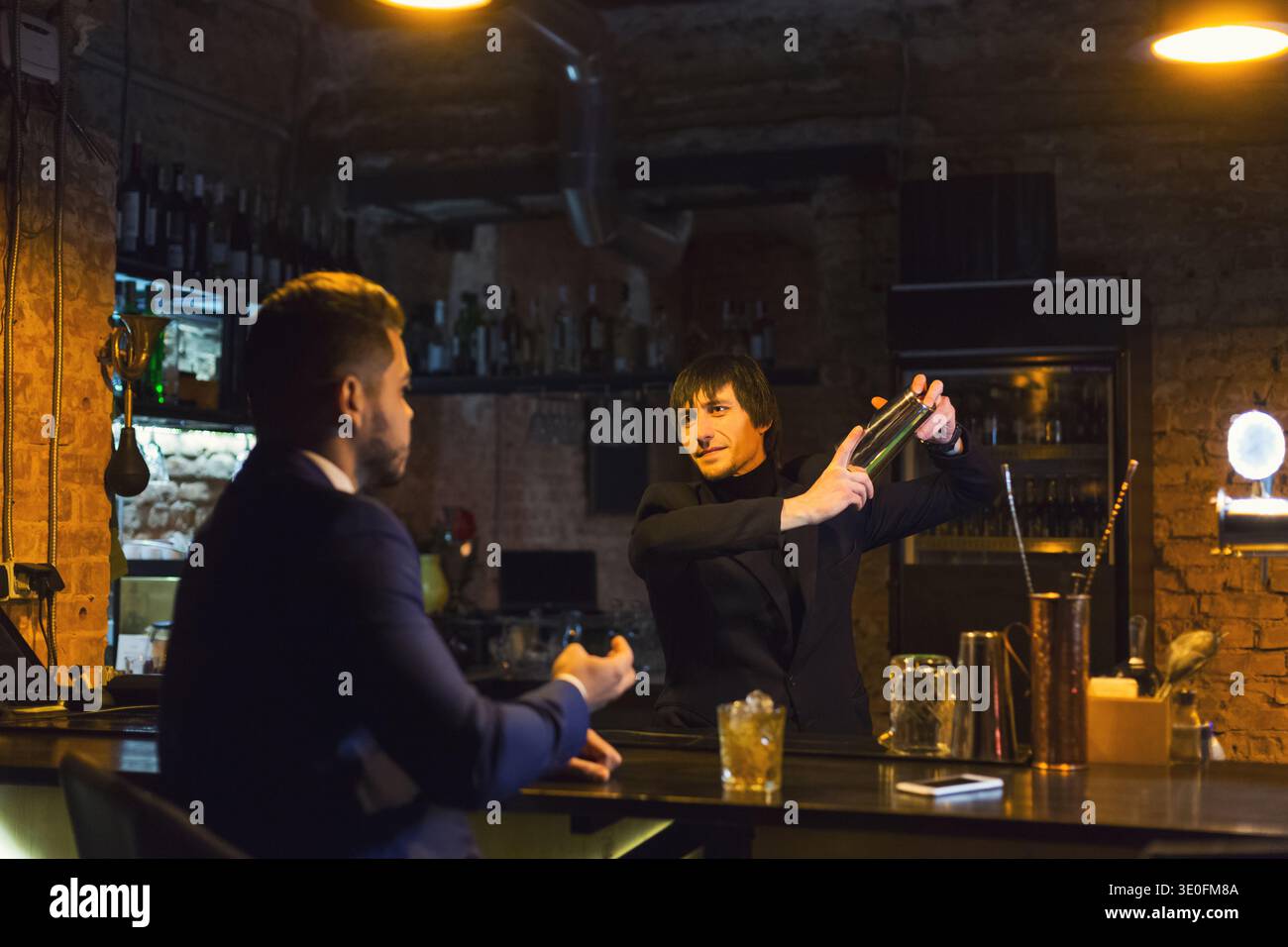 Drunk businessman talking to bartender Stock Photo