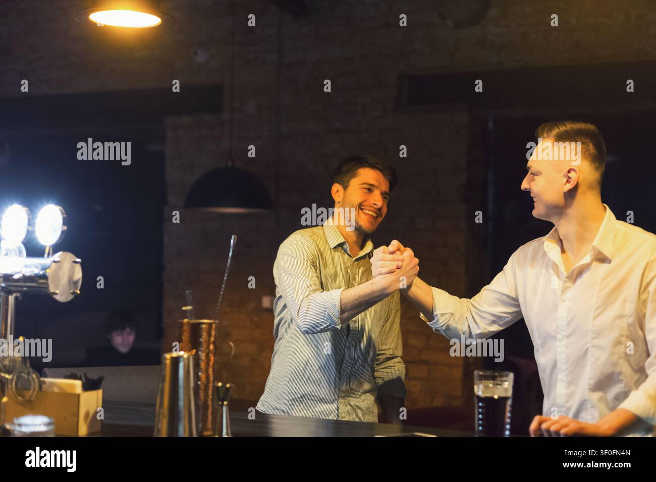 Two cheerful friends meet each other in beer pub Stock Photo