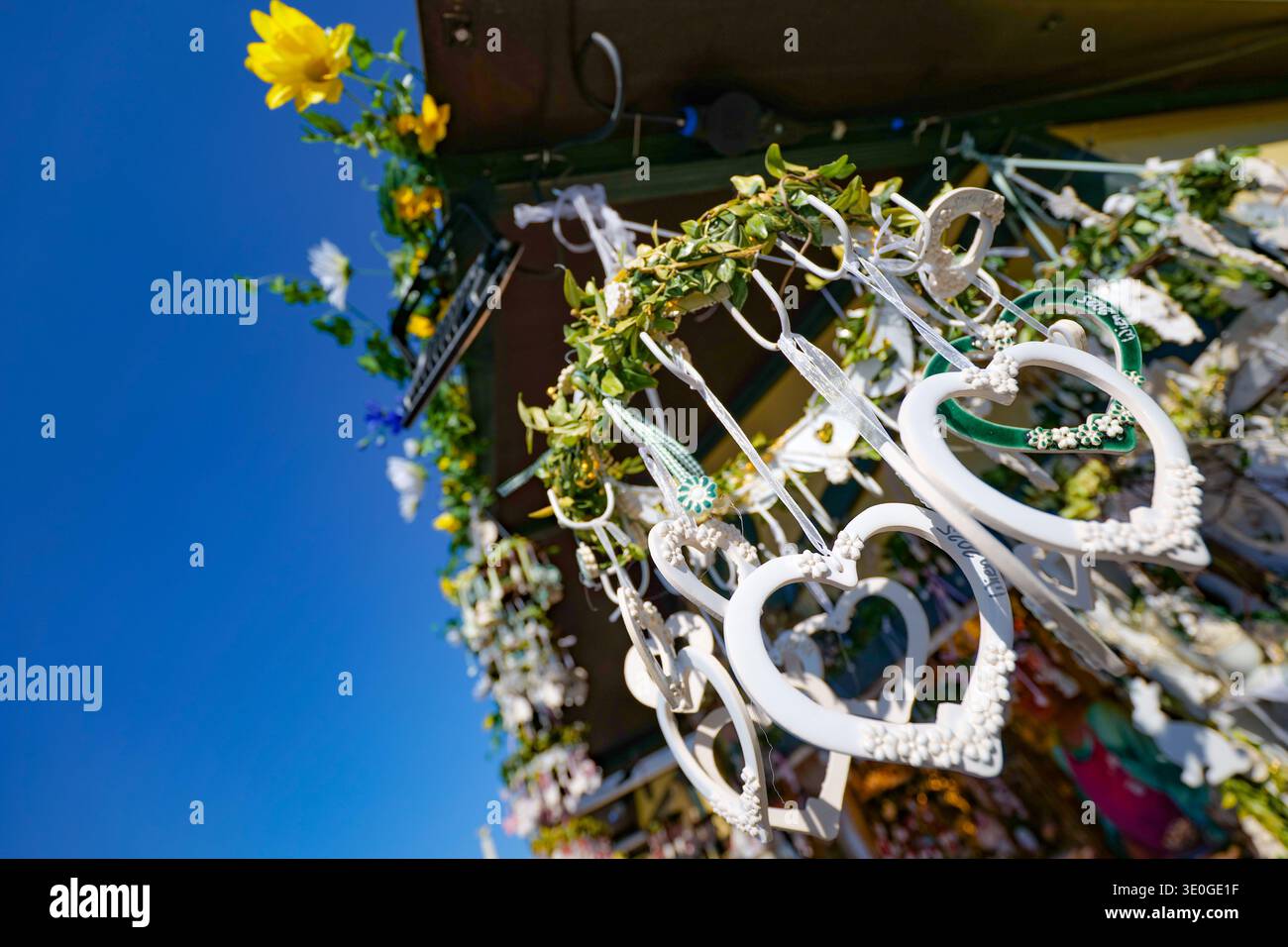 White heart decorations hanging against blue sky Stock Photo
