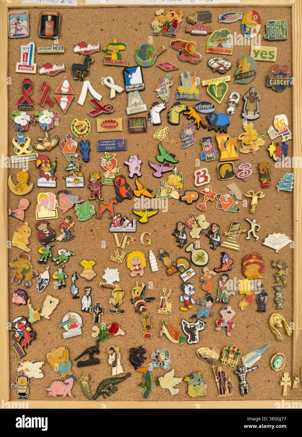 Collection of assorted enamel pins on cork board in Valladolid Stock Photo