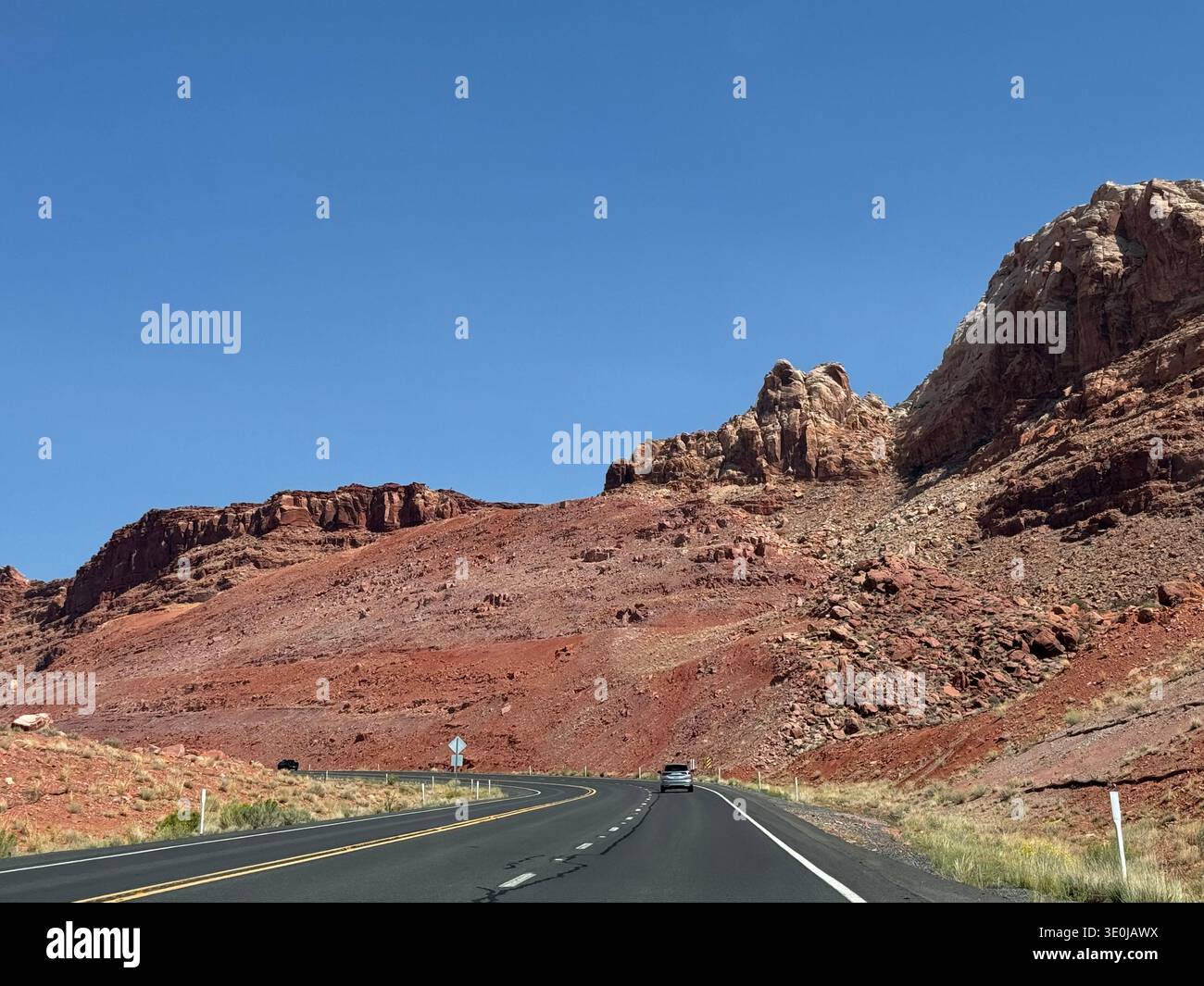 Desert highway winding through red rock formations and rugged landscape in the American Southwest, Utah, USA. - Smartphone Captured Stock Image