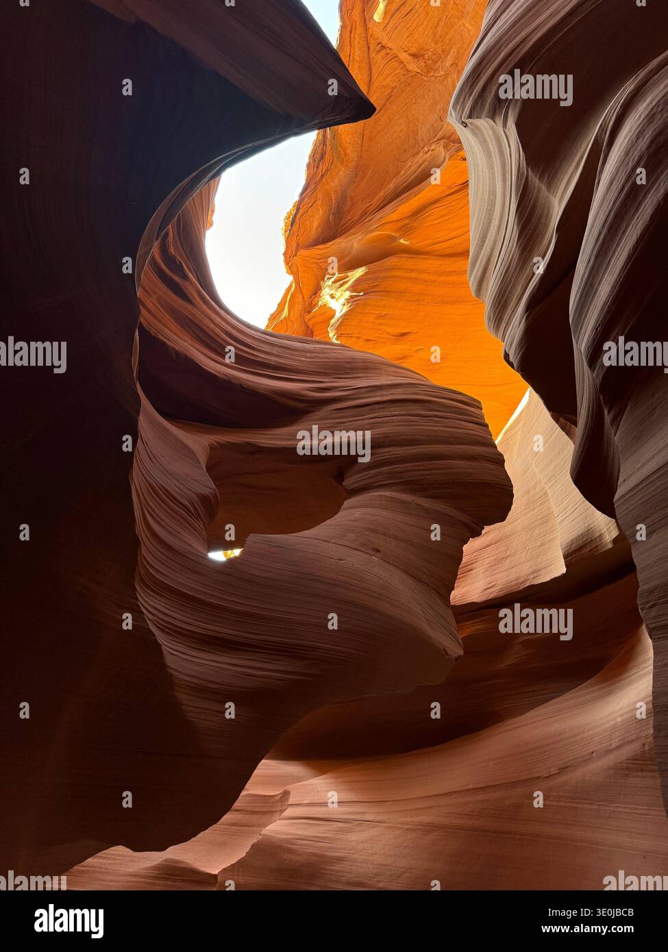 View from inside slot canyon with sculpted sandstone formations and sky visible through narrow opening in Arizona, USA. - Smartphone Captured Stock Image