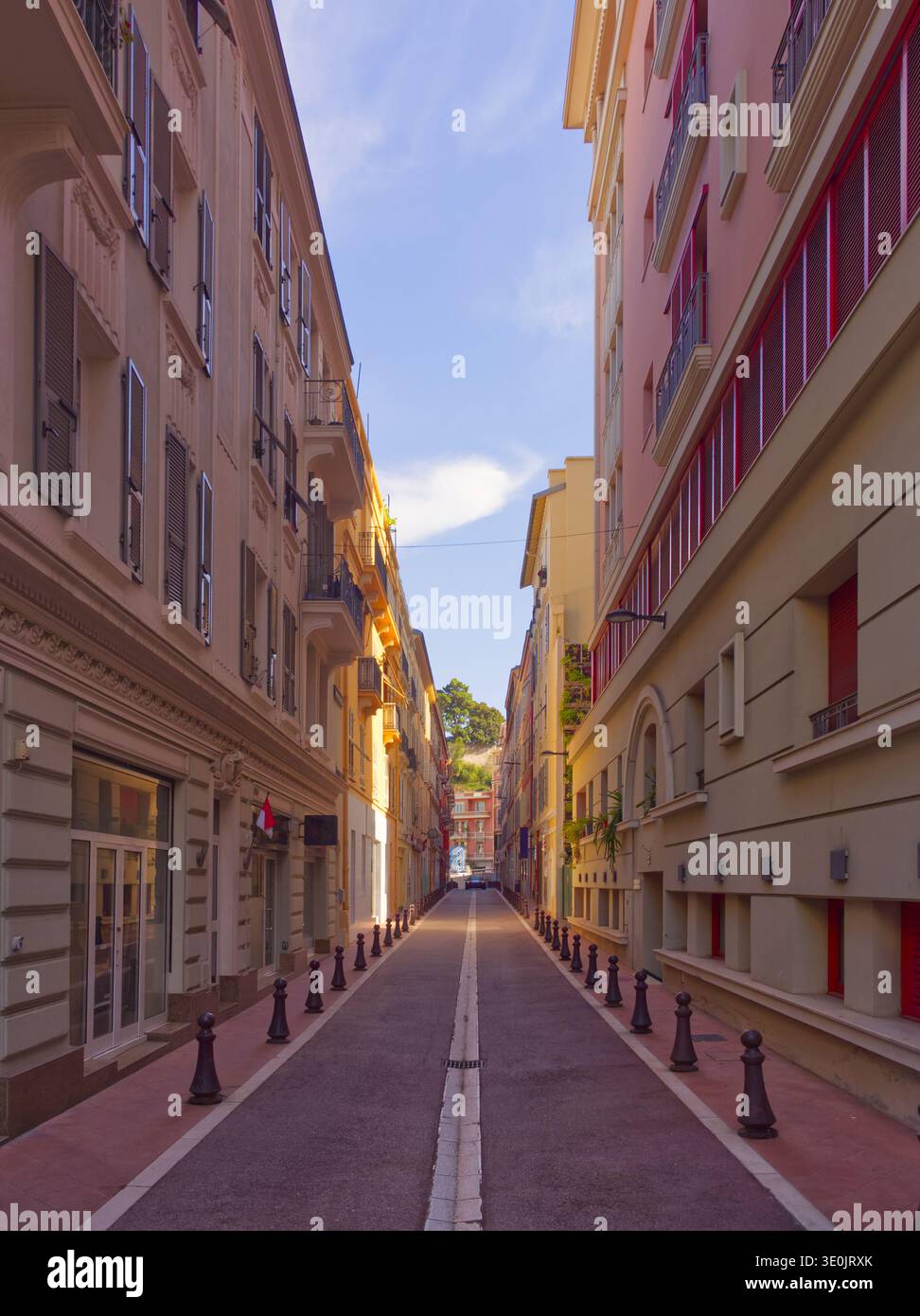 Empty pedestrian street lined with pastel colored apartment buildings in Mediterranean style. Monte Carlo, Monaco. Stock Photo