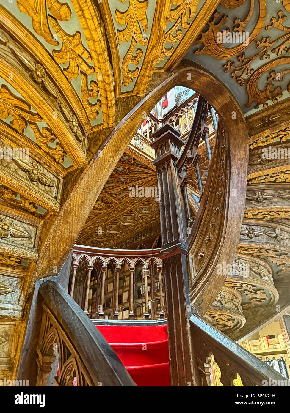 PORTO,. PORTUGAL - JUNE 28, 2025: An ornate carved wooden staircase leads up to the second floor of the library at the Livraria Lello. Stock Photo