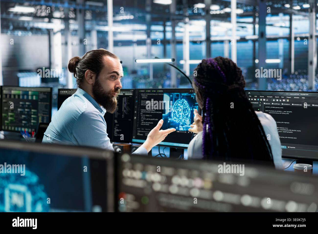 Data center coworkers doing brainstorming, working on databases supporting AI apps. Server room IT staff members cooperating, using artificial intelligence technology to do algorithms improvements Stock Photo