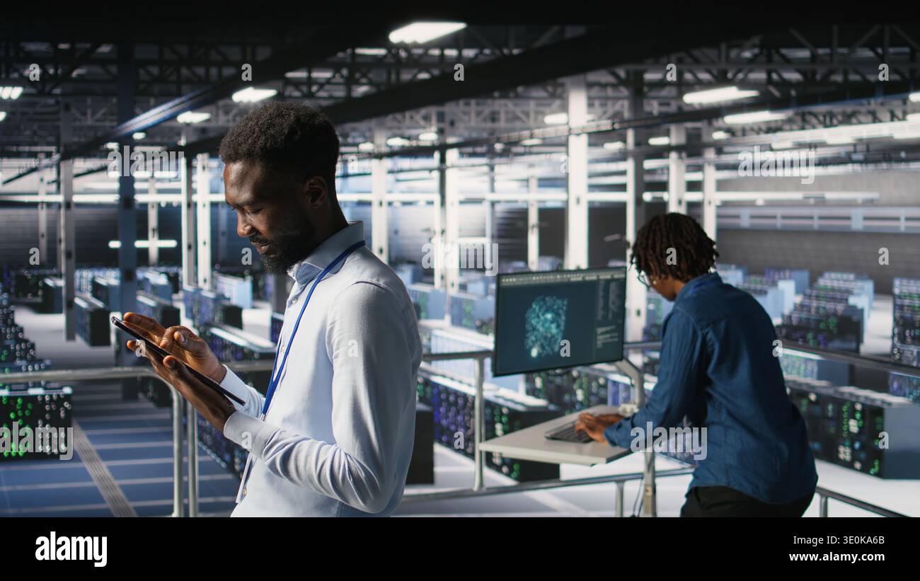 Software developers on data center industrial platform analyzing performance outputs on devices. Server room IT specialists collaborating on finetuning mainframes configurations, Stock Photo