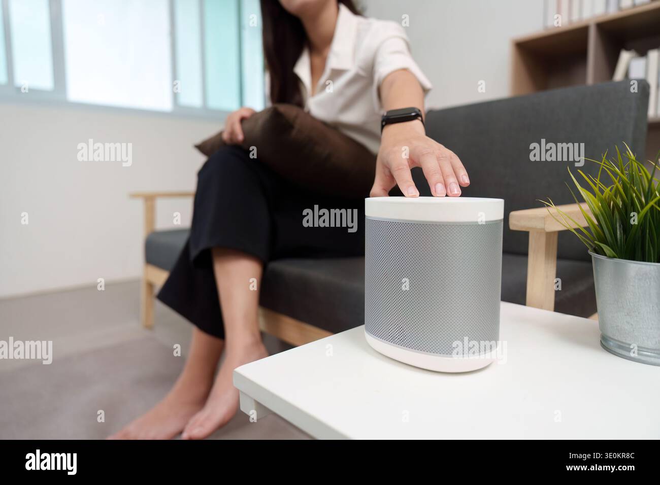 Smart Speaker Control. User adjusting smart speaker settings at home. Stock Photo
