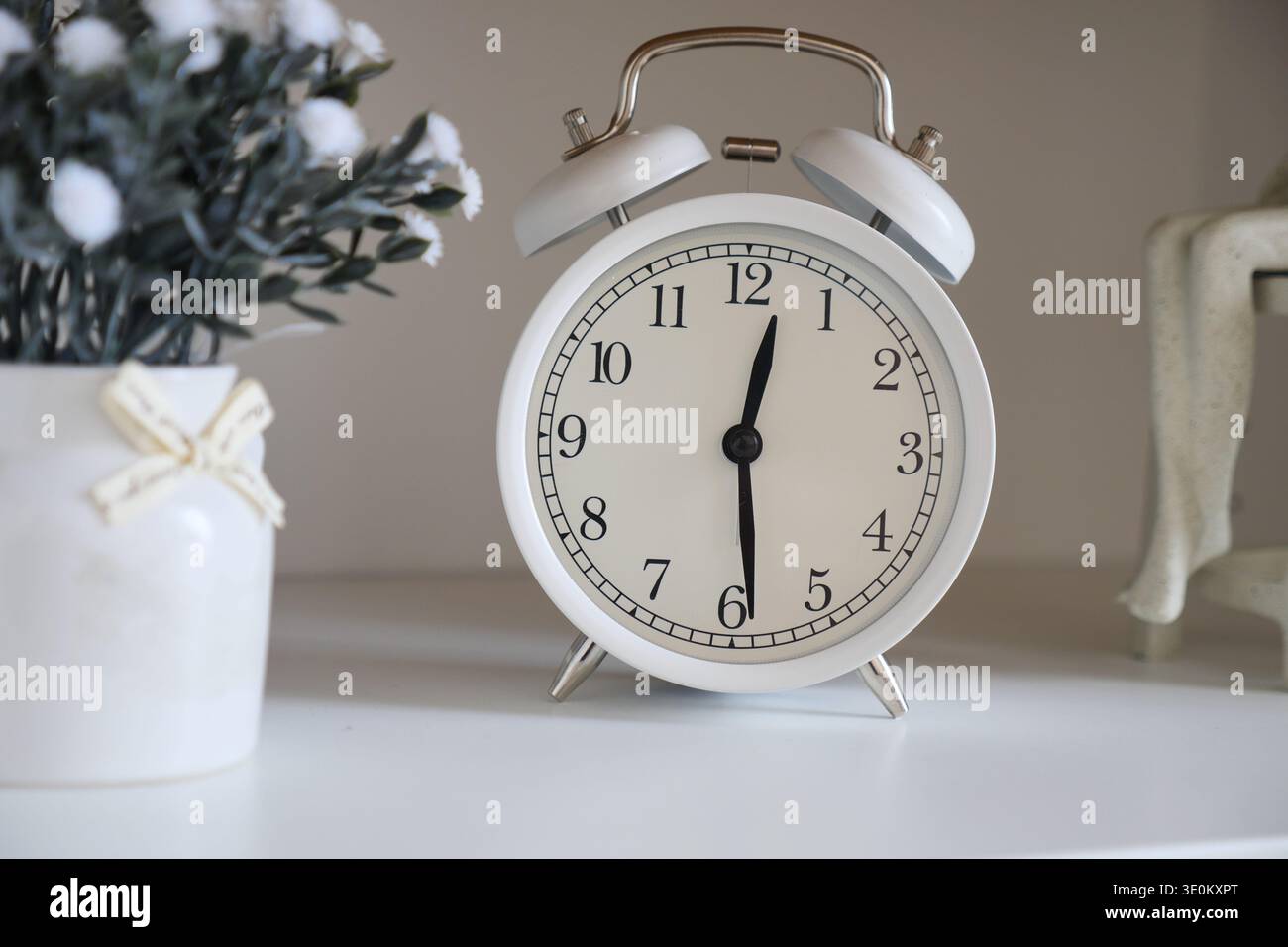 Clock on a shelf with plant decoration and figurine Stock Photo