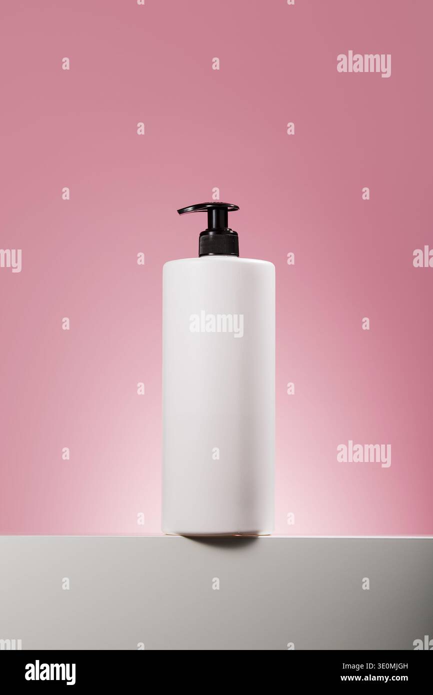 White pump dispenser bottle on pink background Stock Photo