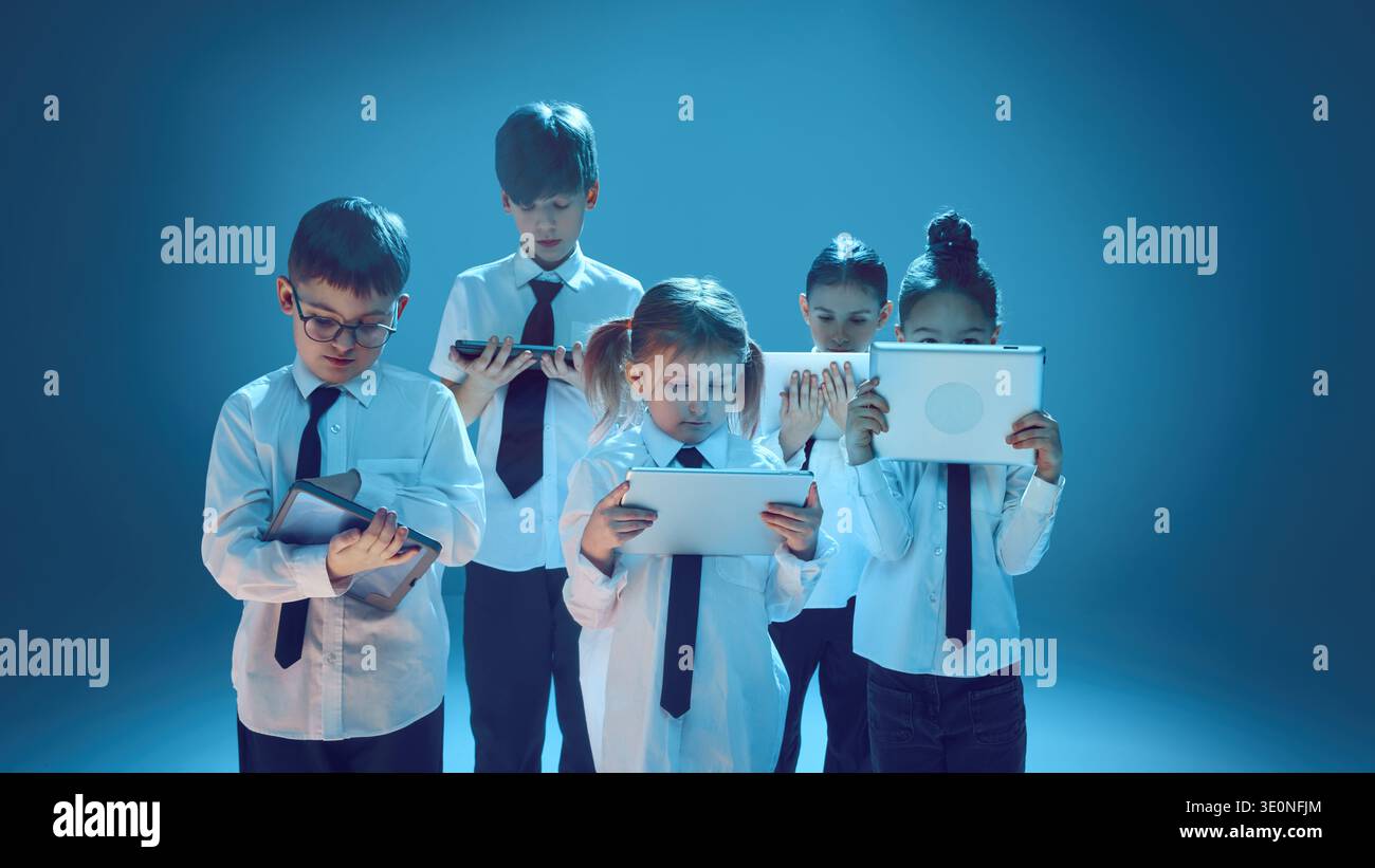Children using tablet devices in neon studio representing digital future concept Stock Photo