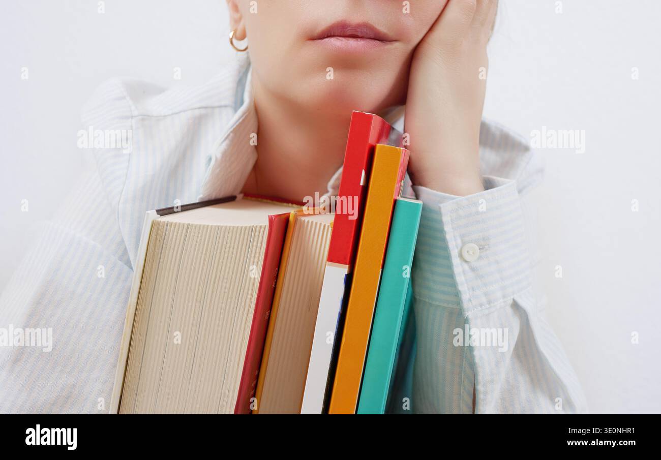 Tired student holding books in hands Stock Photo