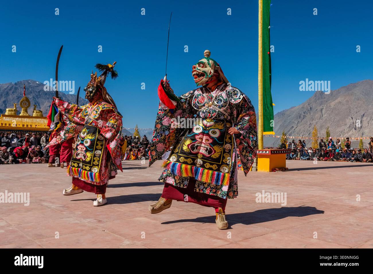 Performers in ornate costumes and masks execute rhythmic movements during the Diskit Gustor festival of the Gelugpa Yellow Hat order. Stock Photo
